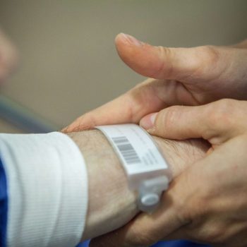 Outpatient surgery, Leon Berard Centre, Lyon, France, This cancer center takes patients to theater standing up, an innovative way of welcoming patients to the operating theater, patients are taken to theater on foot, A patient is treated for dysphagia as a result of stomach cancer. A nurse checks his identity. (Photo by: BSIP/UIG via Getty Images)
